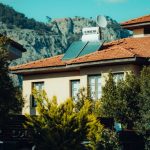 A picturesque urban house with solar panels and mountain view in the background.