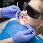 A child receiving dental care wearing protective goggles during treatment.