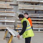 Two workers inspecting materials in a warehouse, focusing on quality control and inventory management.