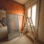An indoor space showing ongoing refurbishment with ladders and construction materials.